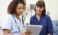 Patient og læge kigger på sundhedsdata