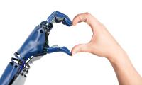 Robothånd og menneskehånd former et hjerte